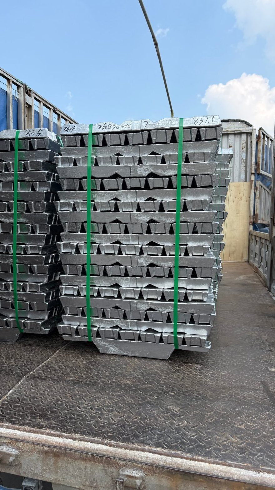 Close-up of stacked ADC12 aluminum ingots before being melted at a die-casting plant