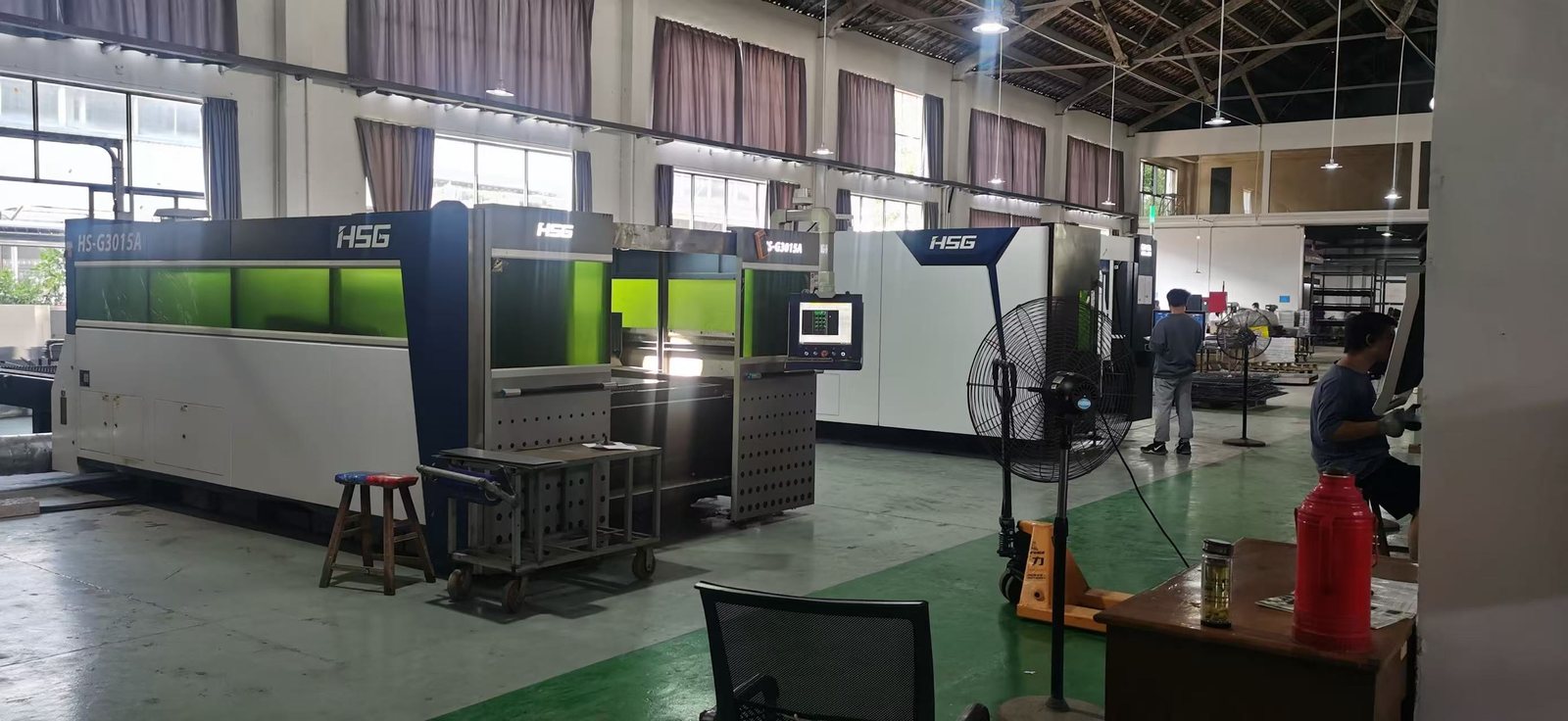 Wide view of the sheet metal shop floor, cutting and forming equipment in one bay